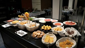 A buffet with various pastries, meats, and fruits. - Hotel Oriente (Zaragoza)