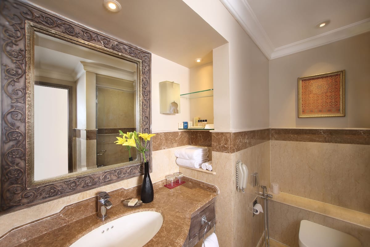 deluxe room, 1 king bed, pool view | bathroom | combined shower/bathtub, deep-soaking bathtub, free toiletries