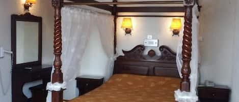 A four-poster bed with a canopy, two wall-mounted lamps, and a ceiling light fixture.