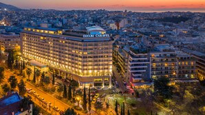 Un hôtel à plusieurs étages, reconnaissable à son enseigne bien visible, entouré d’autres bâtiments et offrant une vue sur le paysage urbain au crépuscule.