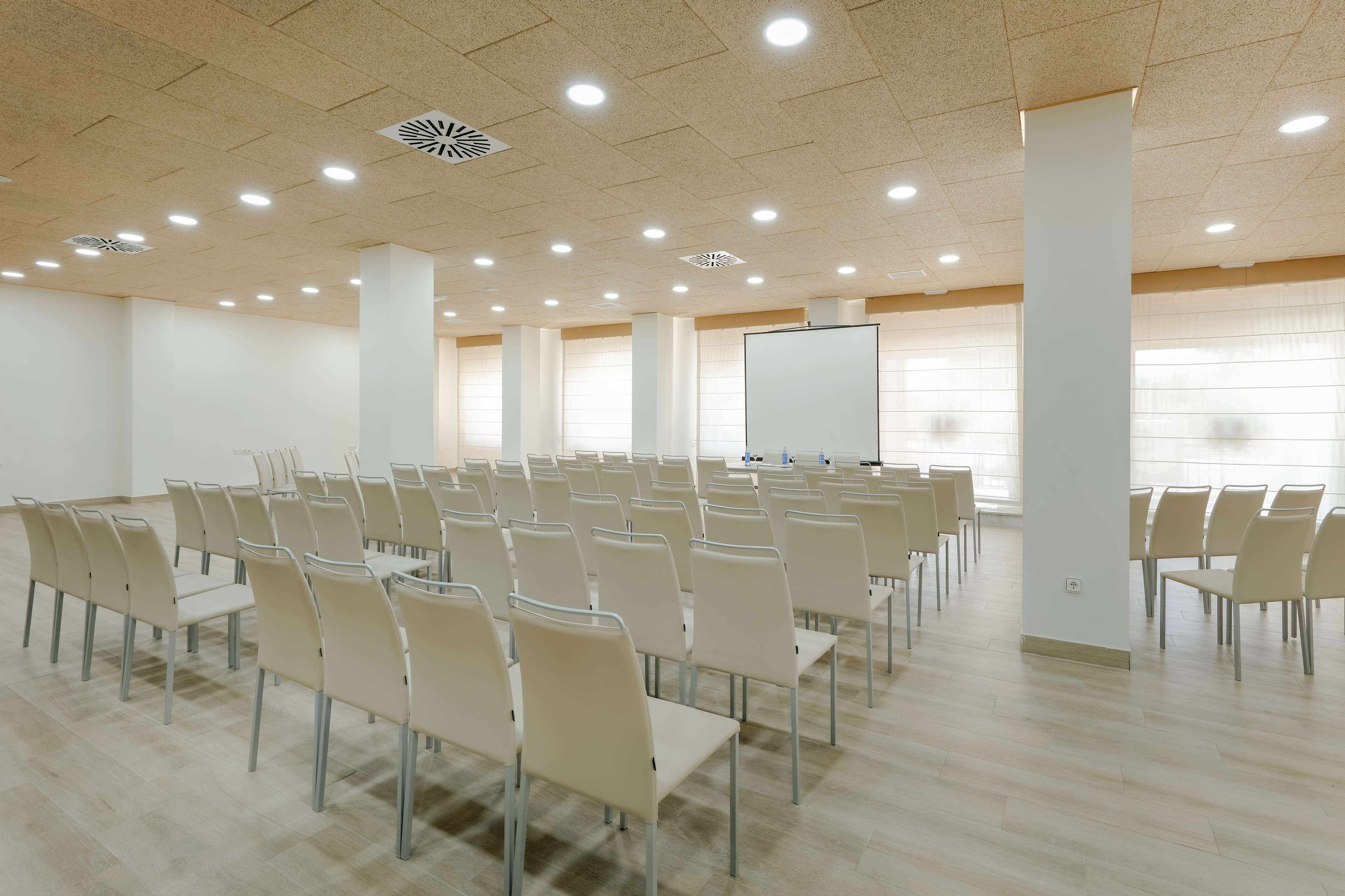 A conference room with rows of chairs and a whiteboard.