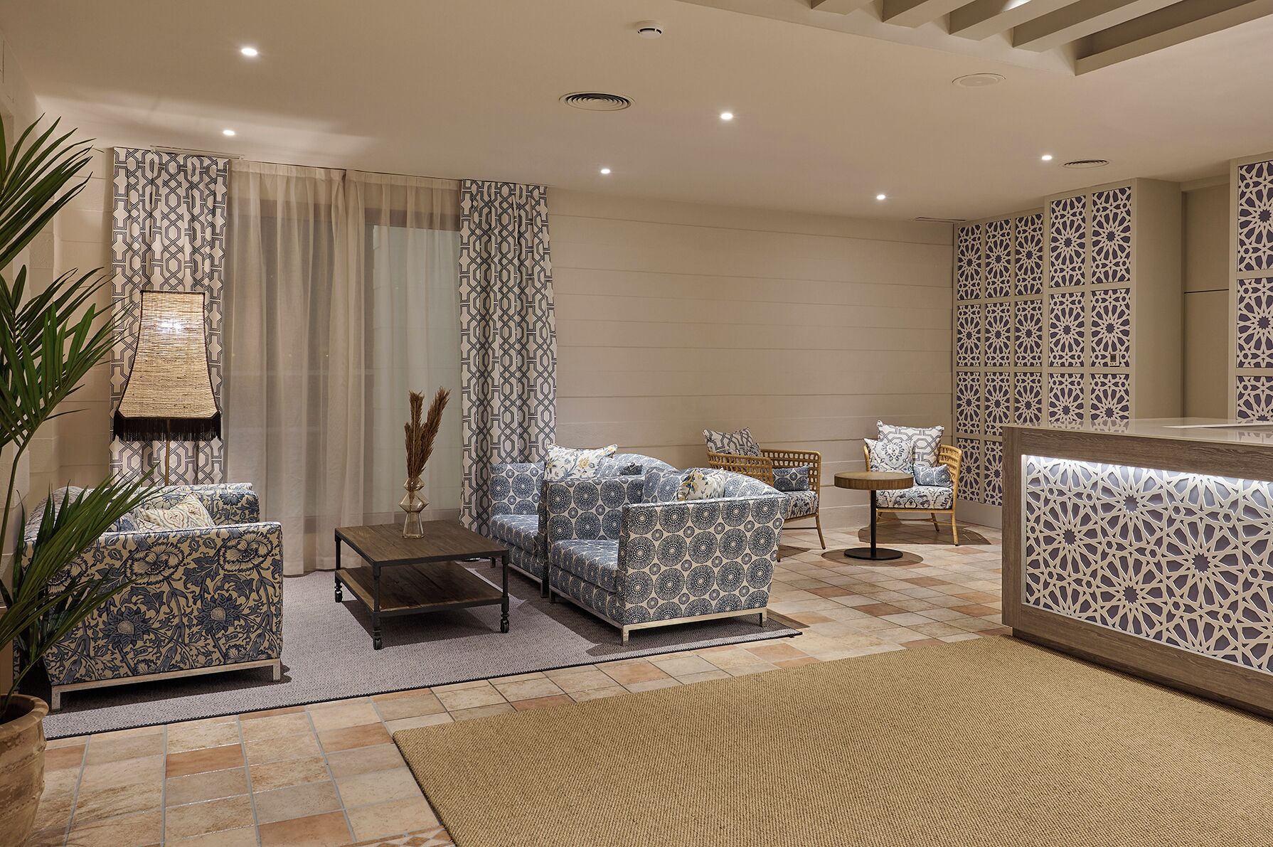 A modern living room with patterned sofas, a coffee table, and a decorative wall panel.