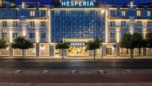 A hotel with a modern facade, multiple balconies, and a prominent entrance.