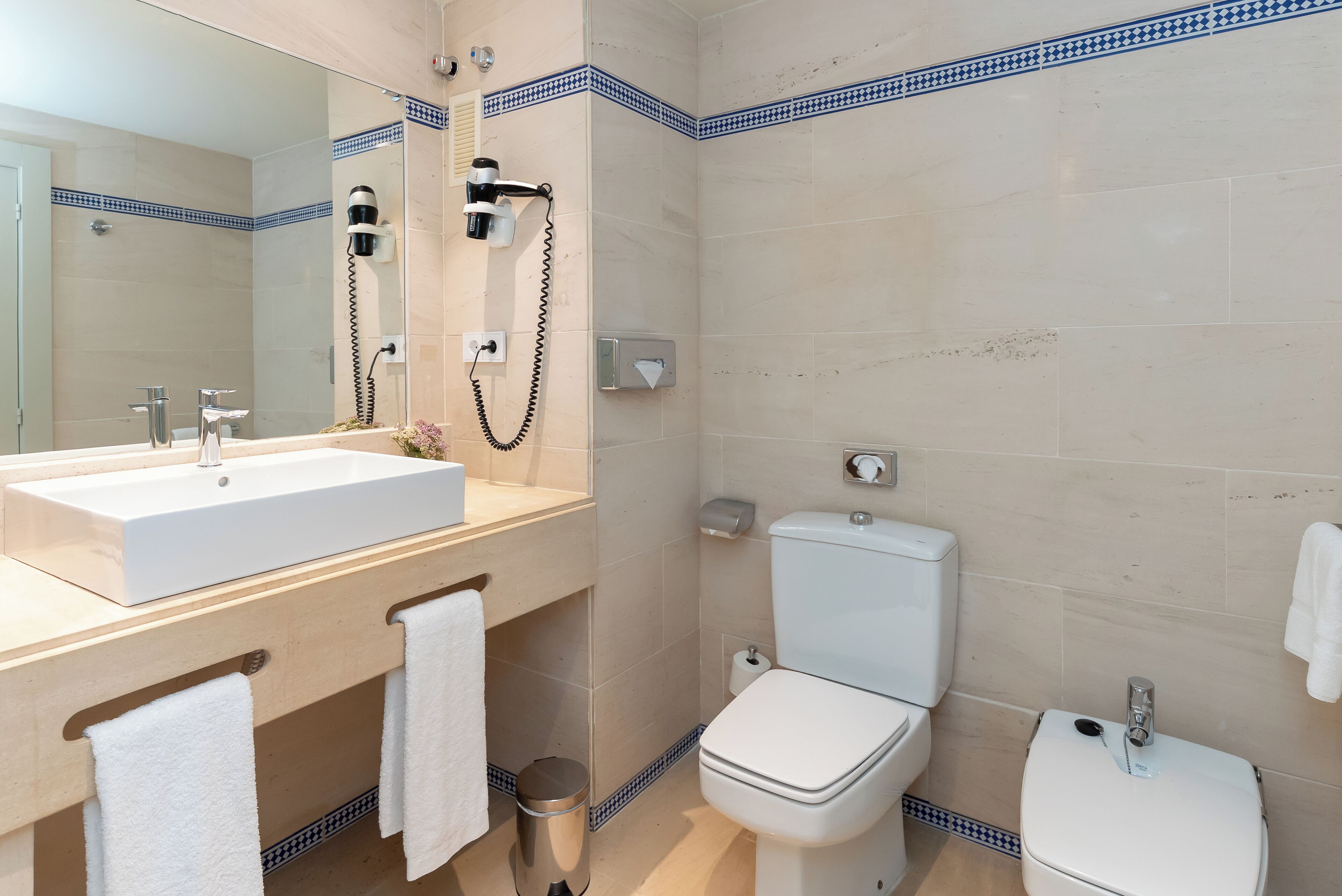 Un baño moderno con un lavamanos grande, un inodoro y una zona de ducha.