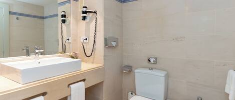 Un baño moderno con un lavamanos grande, un inodoro y una zona de ducha.