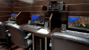 Un espacio de oficina moderno con tres escritorios, cada uno equipado con una computadora de escritorio, teclado y monitor.