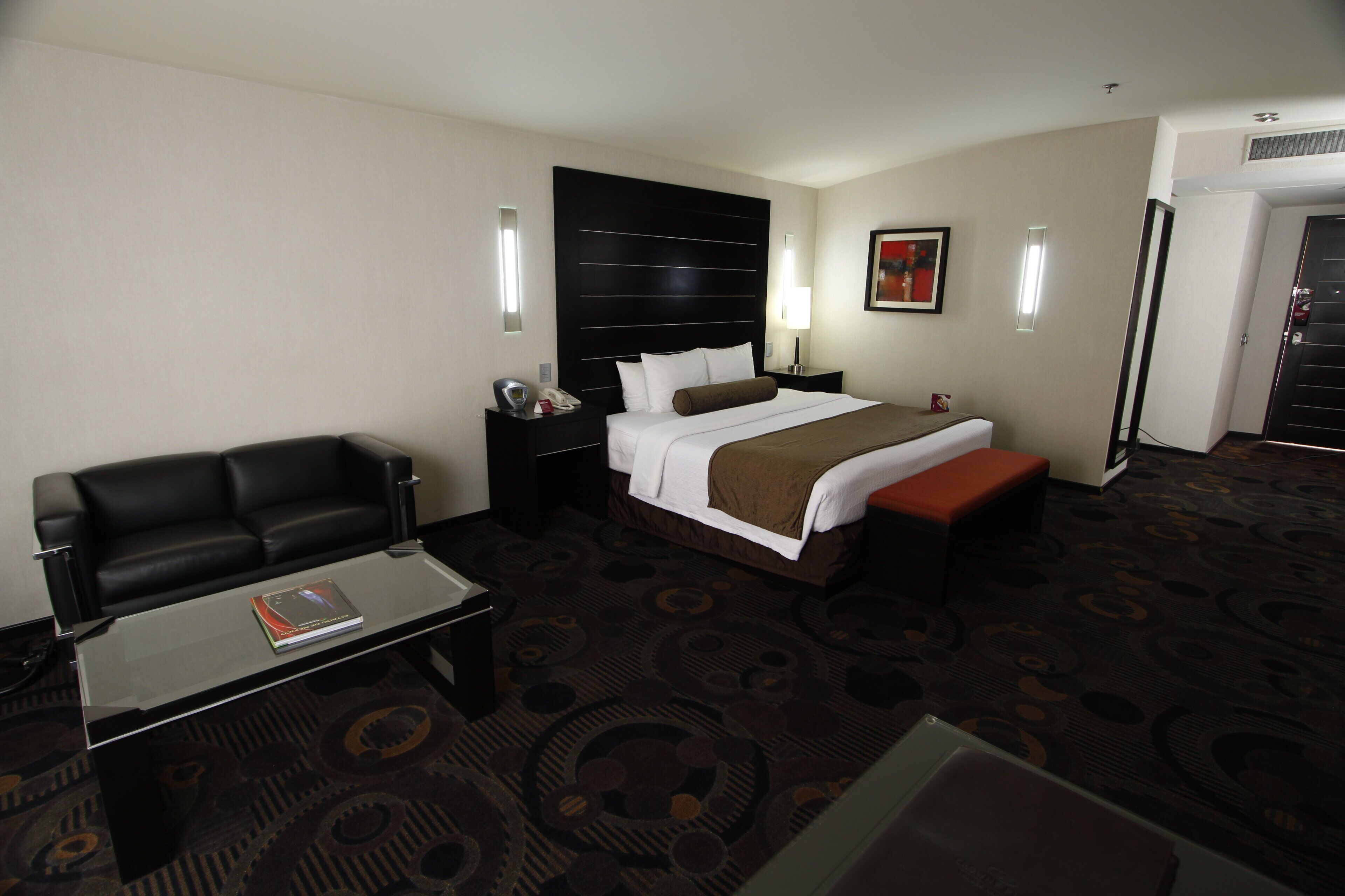 Ein Hotelzimmer mit einem Bett, einem Schreibtisch, einem Stuhl und einer Couch.