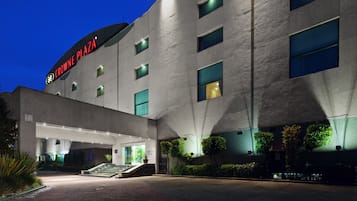 Un hotel de diseño moderno, con una entrada destacada y escalones que conducen a la puerta principal.
