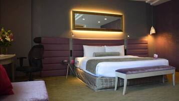 Moderni hotellihuone, jossa on suuri sänky, työpöytä ja tuoli.