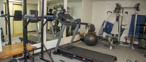 A gym with cardio equipment, weight machines, and free weights.