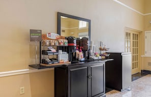 Ein Frühstücksbuffet zum Mitnehmen mit Kaffeemaschinen, Kaffeeausgabe und verschiedenen Speisen.