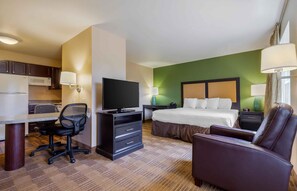 A hotel room with a bed, desk, chair, television, and a green accent wall. - Extended Stay America Suites - Columbia - Northwest/Harbison (Irmo)