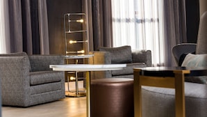 A modern living room with a sectional sofa, a round coffee table, and a floor lamp with lights.