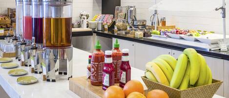 A buffet setup with various food items and condiments.