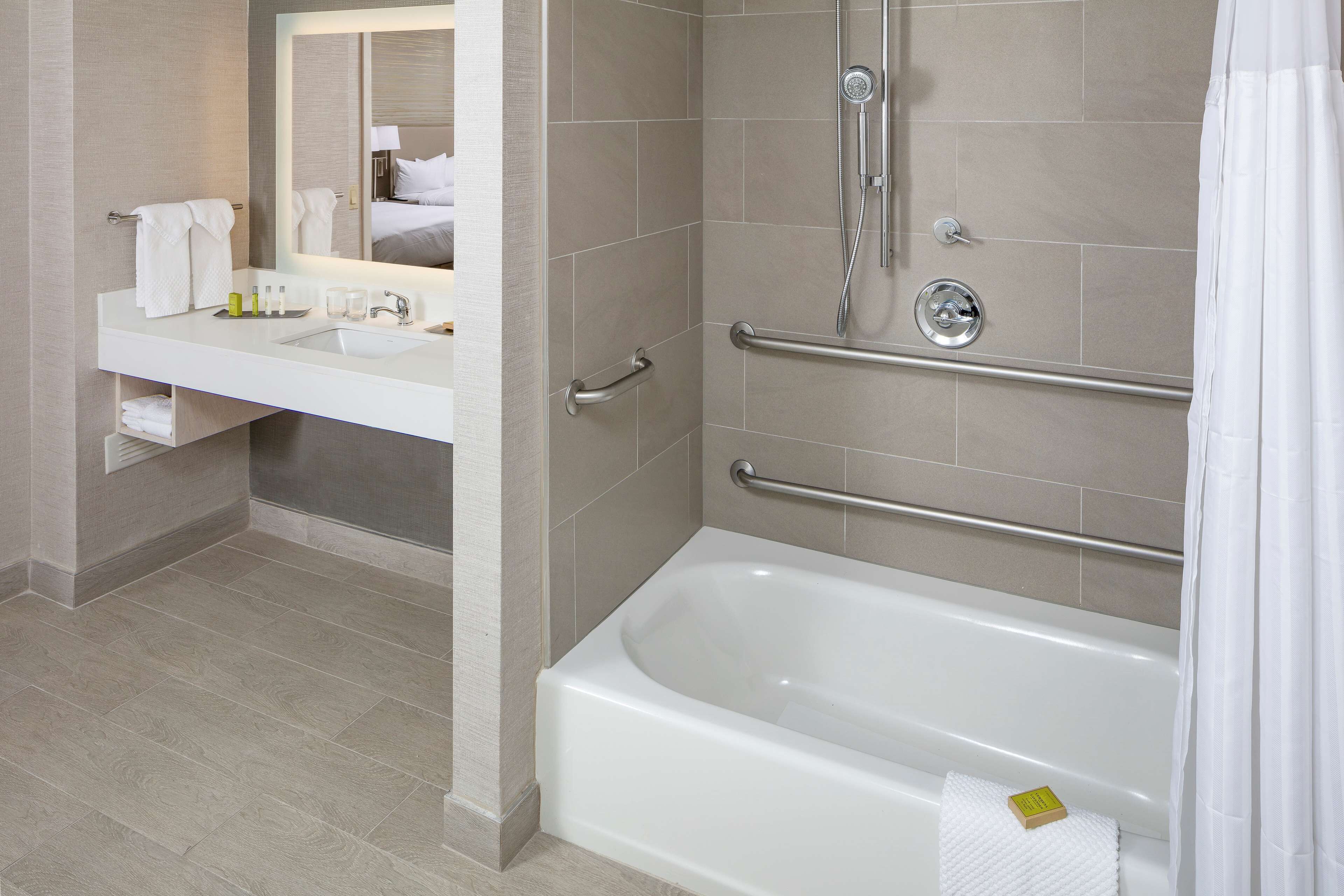 Un baño moderno con bañera, zona de ducha y tocador con espejo.
