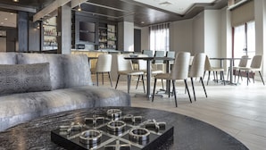 A modern interior with a bar area, seating, and a unique black coffee table.