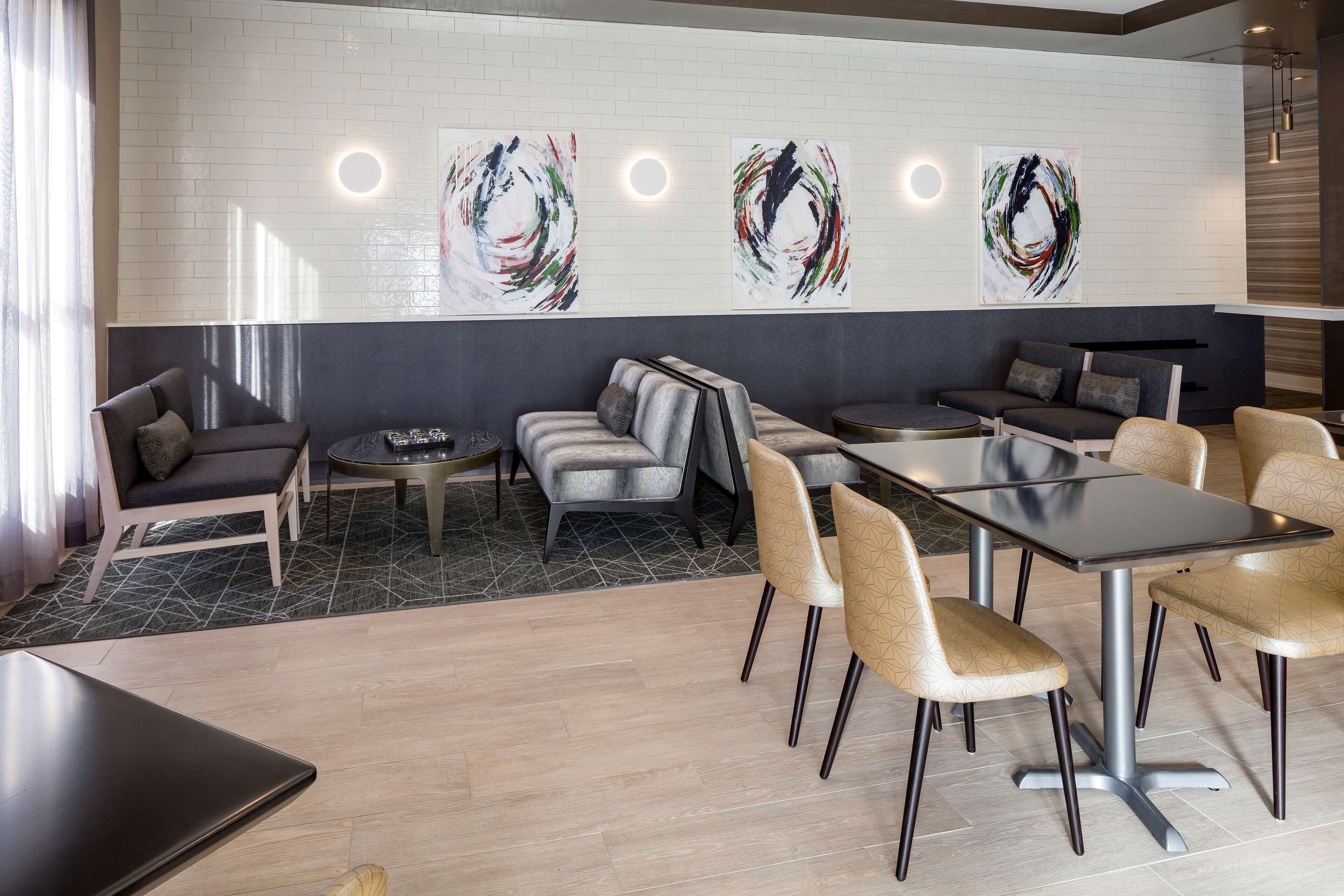 A modern lounge area with a sofa, chairs, and a dining table.