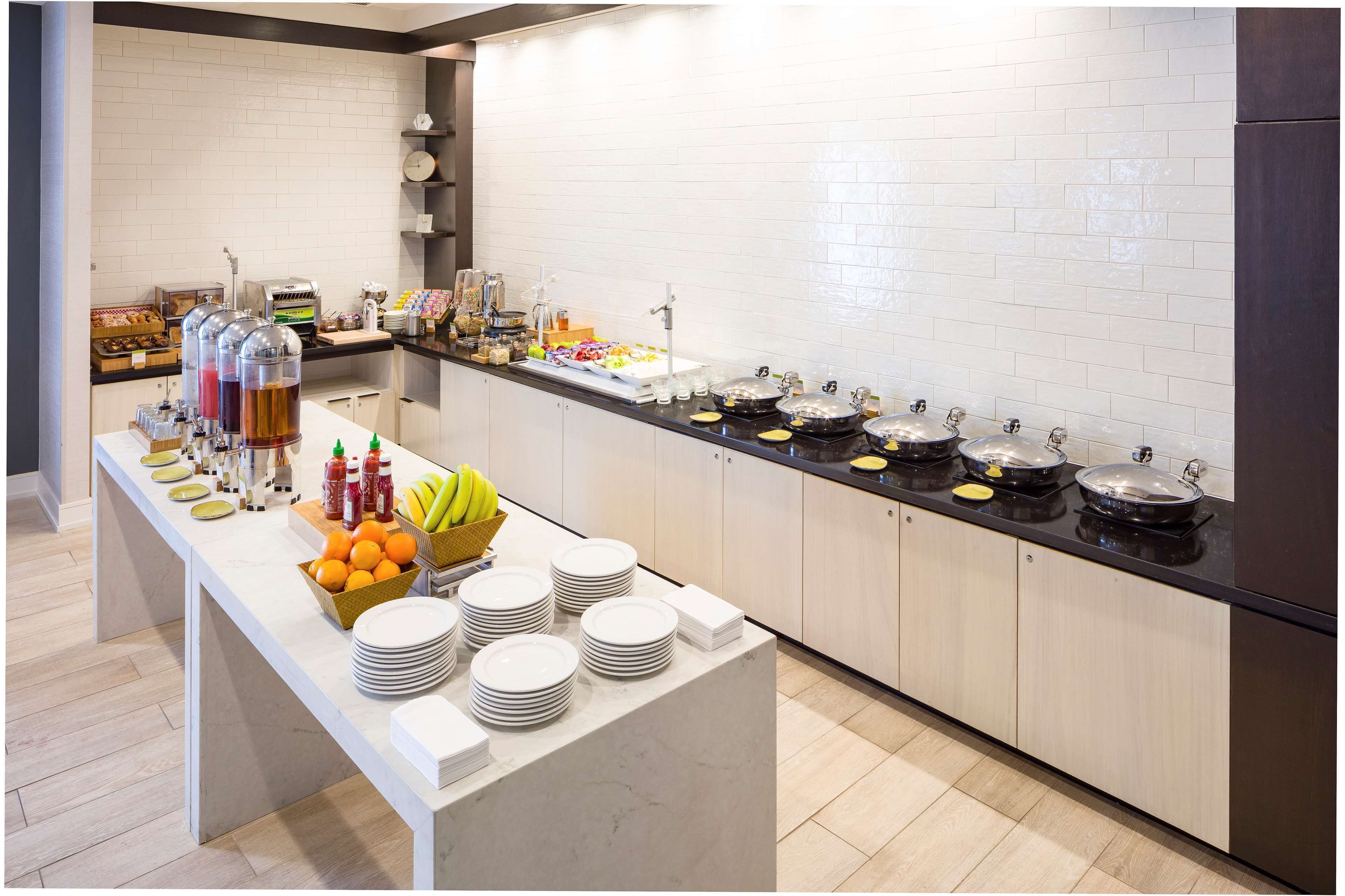 A buffet setup with various food items and condiments.