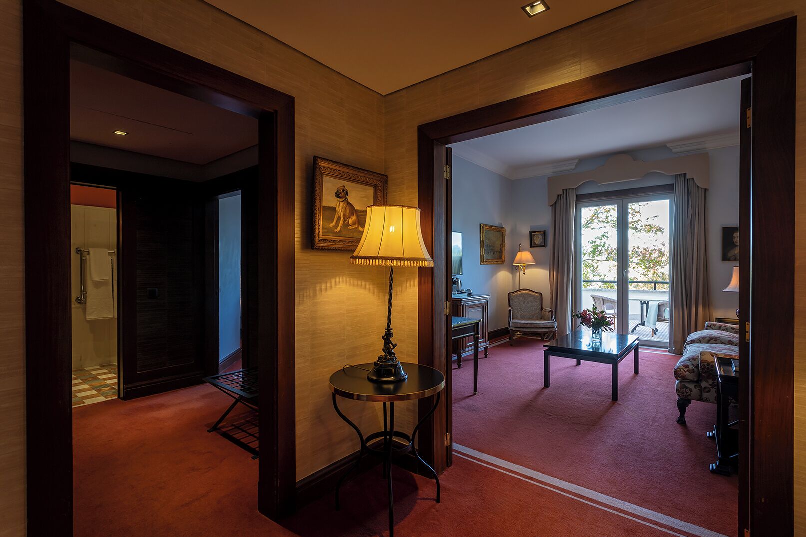 Un hall d’hôtel avec une table ronde, une lampe, une chaise et un canapé.