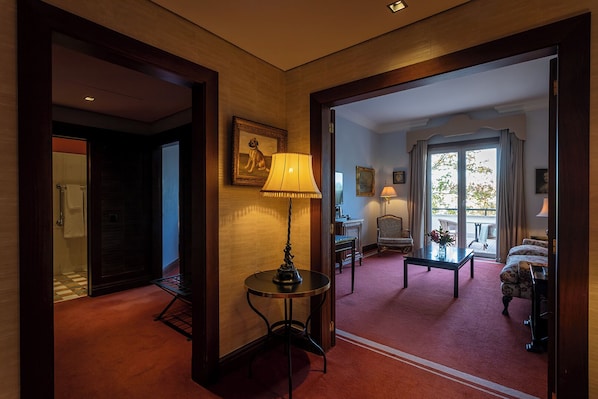 Un vestíbulo de hotel con una mesa redonda, una lámpara, una silla y un sofá.