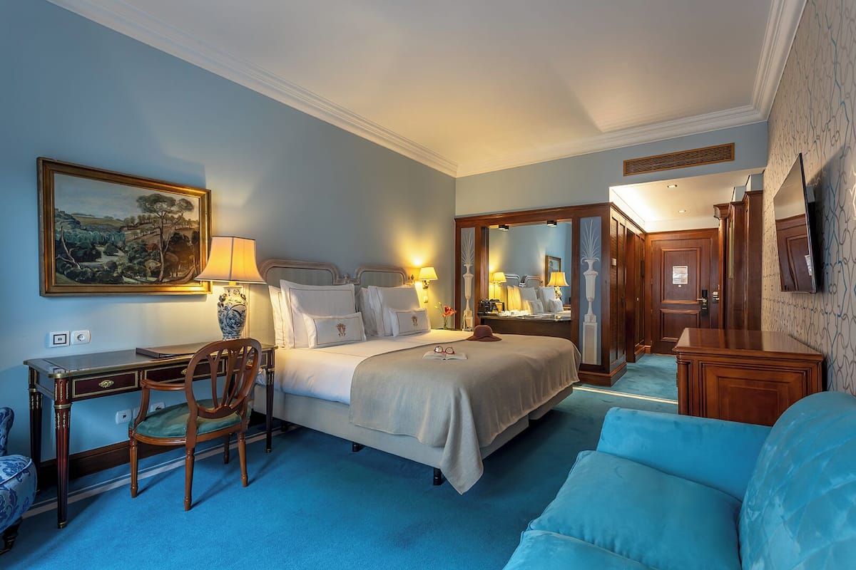 Une chambre d’hôtel équipée d’un lit, d’un bureau, d’une chaise et d’un téléviseur.