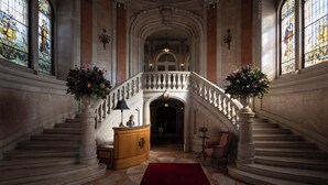 A grand staircase with a red carpet, ornate columns, and stained glass windows. -  Pestana Palace Lisboa Hotel & National Monument - The Leading Hotels of the World (Lisbon)