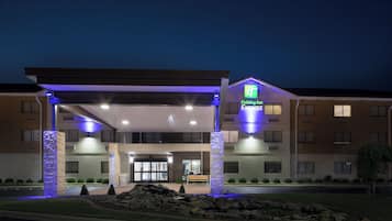 Un bâtiment de l’hôtel Holiday Inn Express doté d’une entrée abritée, de piliers en pierre et d’un espace paysager agrémenté de rochers et d’arbustes.