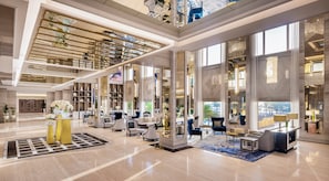 A spacious lobby with high ceilings, large windows, and a central seating area with sofas and chairs. - InterContinental Doha Beach & Spa by IHG (Doha)