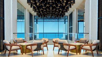 A modern interior with a seating area facing a large window overlooking the sea.