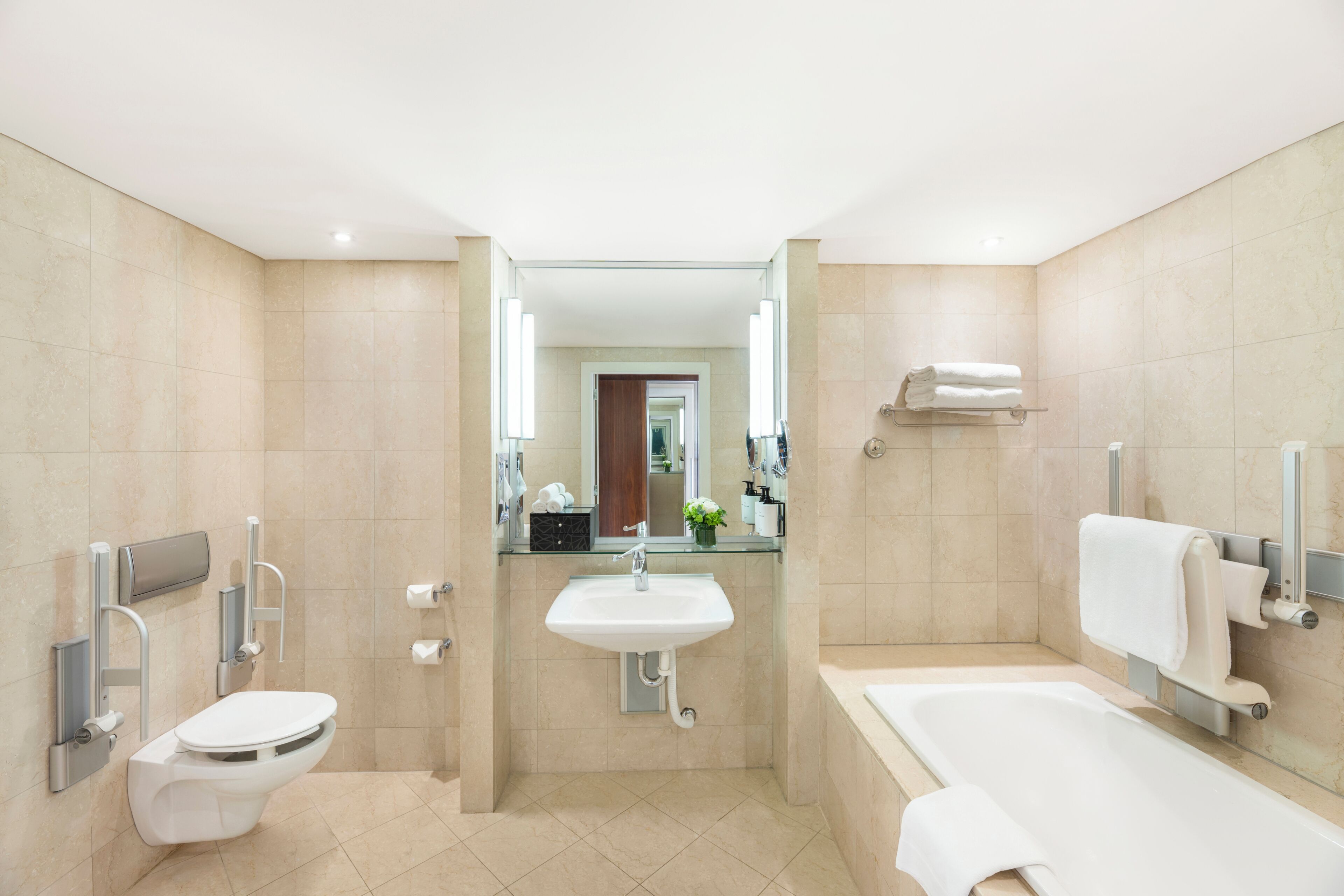 A modern bathroom with a toilet, sink, and bathtub.
