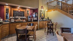 Un restaurant avec des meubles en bois, un menu écrit à la craie et un escalier.
