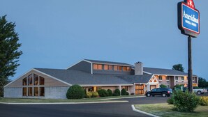 Un motel à deux étages, doté d’une enseigne bien visible, d’une allée et d’un espace de stationnement.