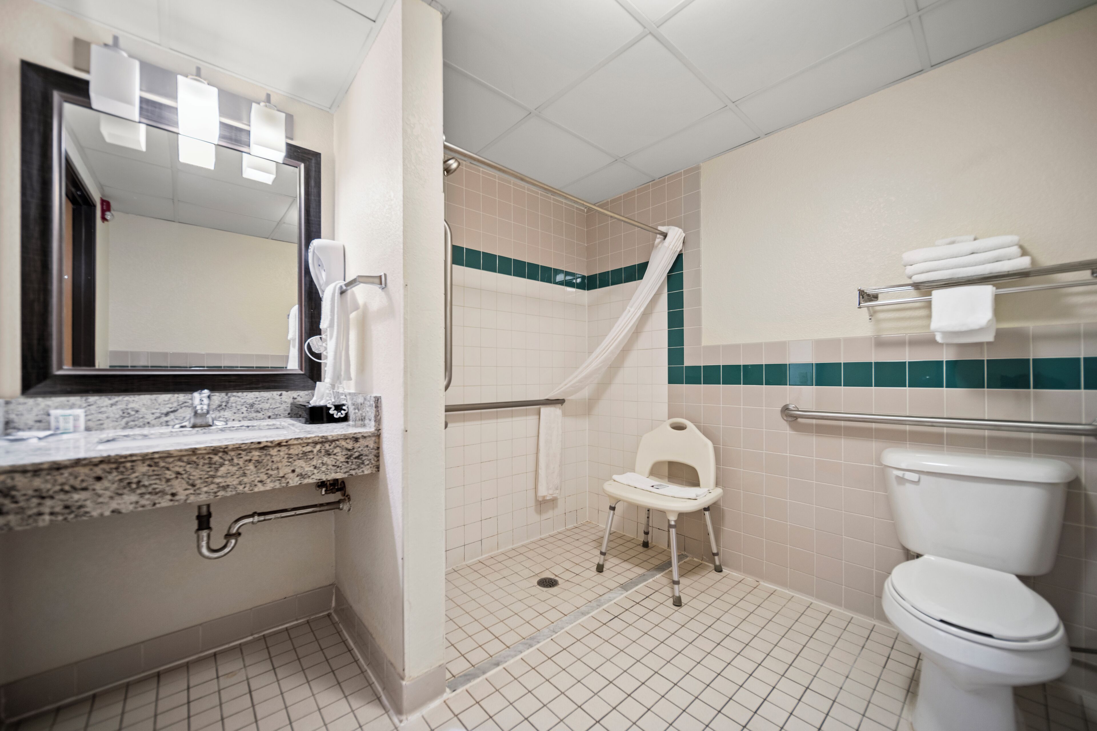 Un baño con ducha, inodoro y tocador.