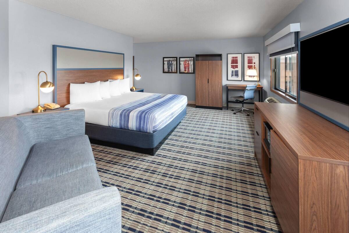 Een hotelkamer met een bed, een bank, een bureau en een televisie.