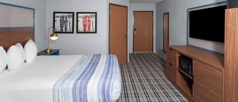 Una habitación de hotel con una cama, televisor, escritorio y microondas.
