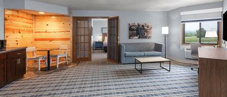 Una sala de estar moderna con una pared de acento de madera, un sofá, una mesa de centro y un televisor.