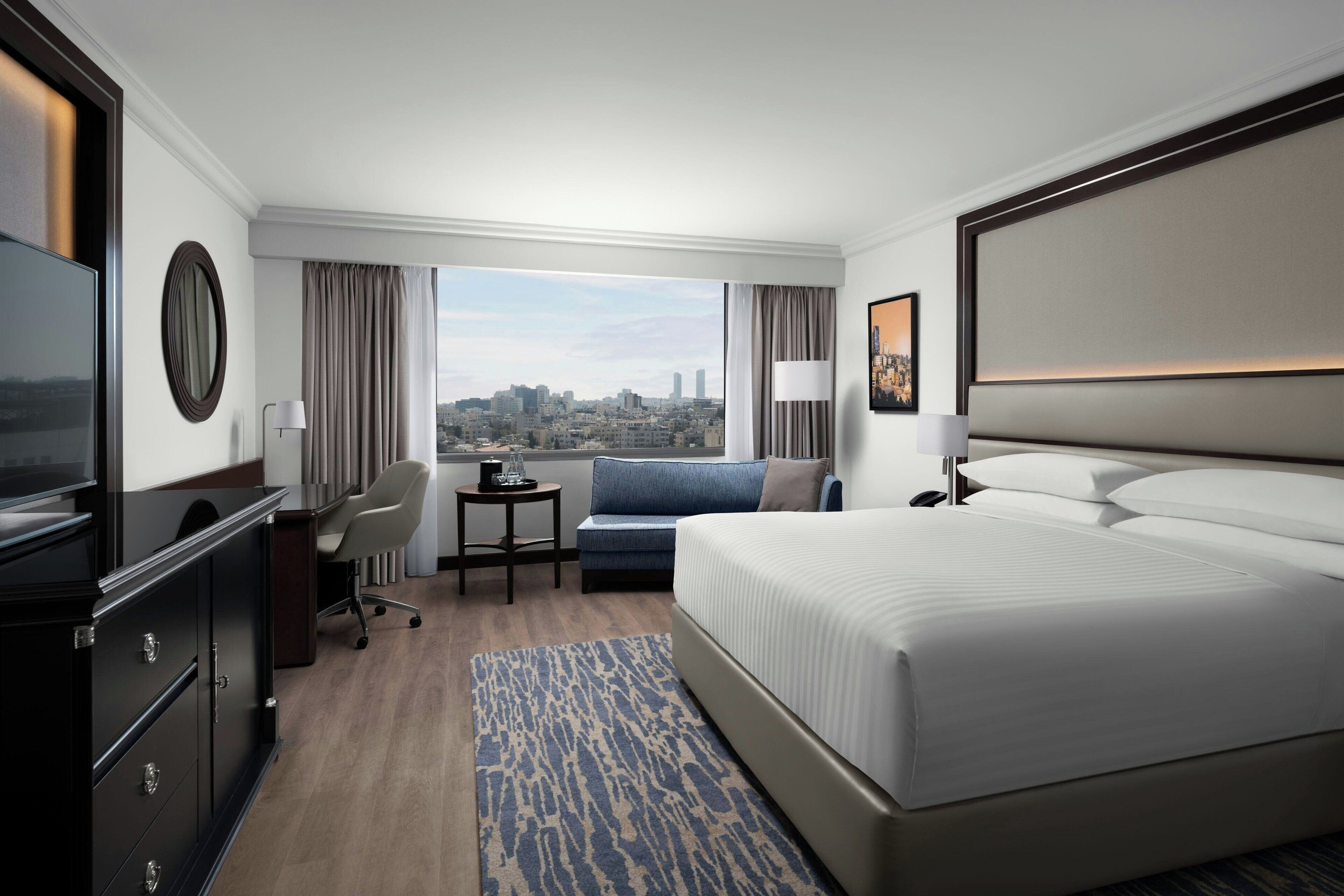 أغطية فراش متميزة وميني بار وخزنة داخل الغرفة ومكتب