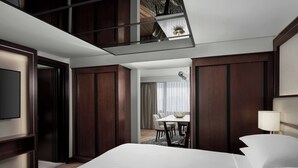 A hotel room with a large bed, a desk, and a dining area with chairs and a table. - Amman Marriott Hotel (Amman)