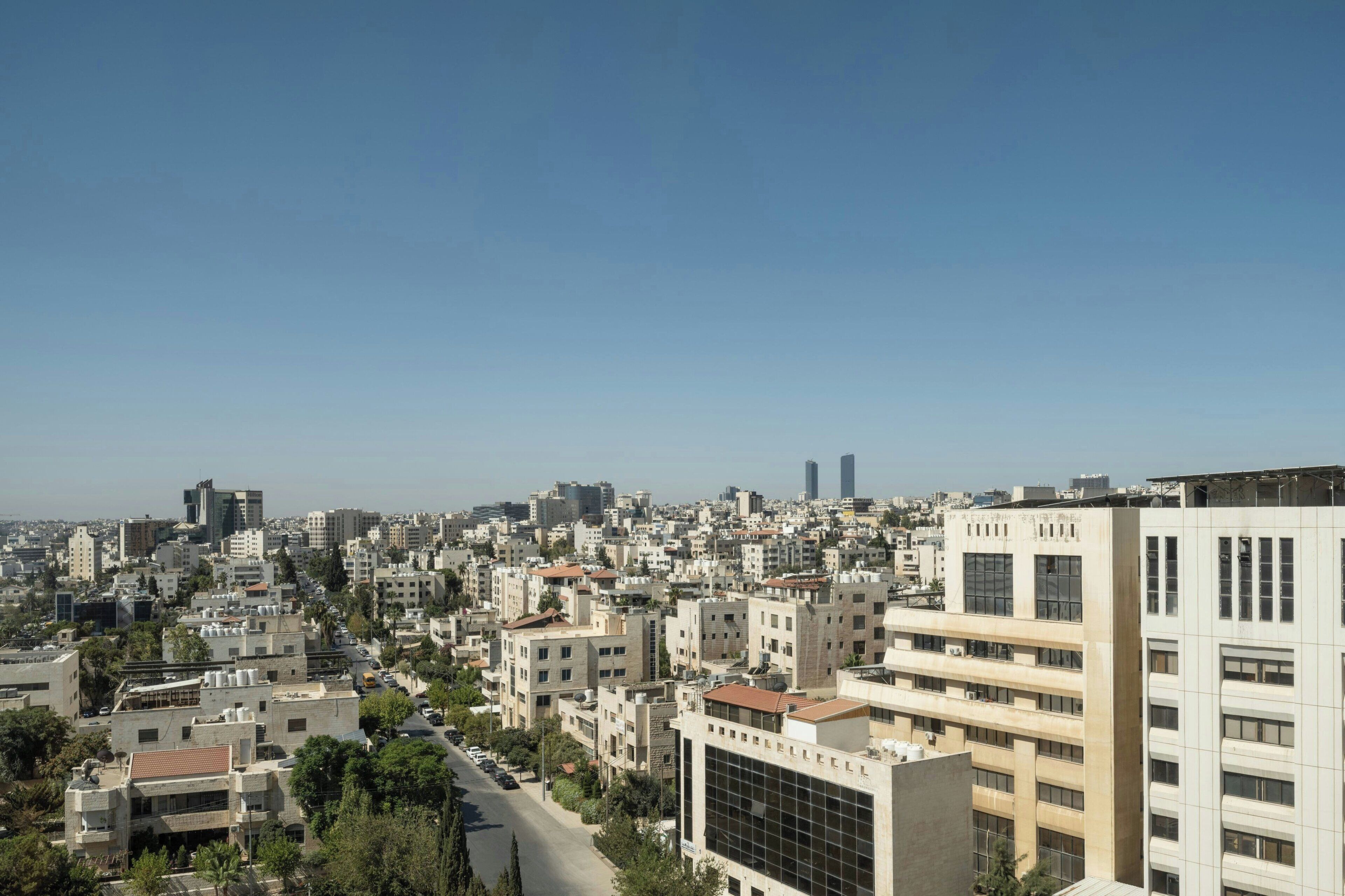 Une vue urbaine avec de nombreux bâtiments, des routes et un ciel dégagé.