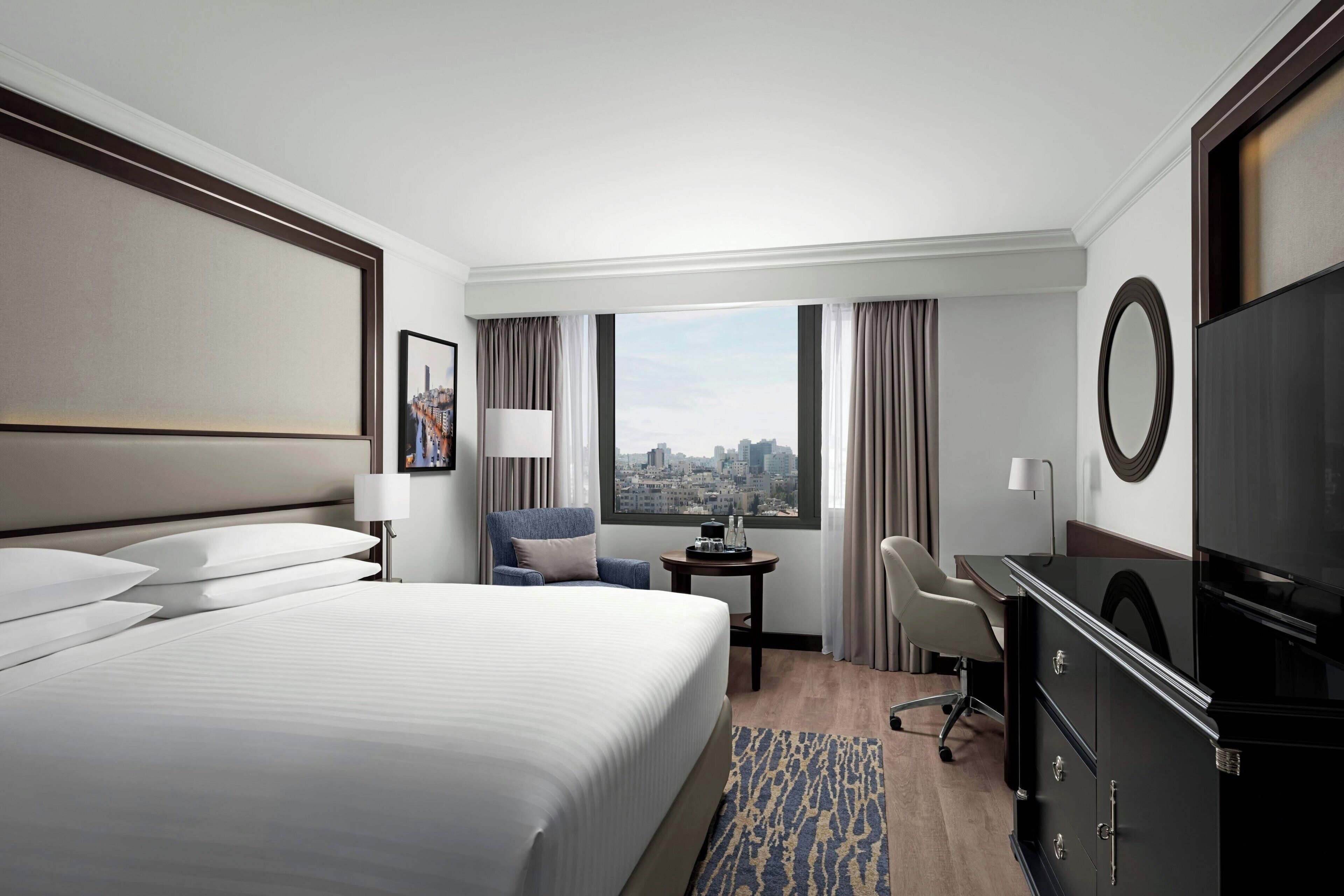 أغطية فراش متميزة وميني بار وخزنة داخل الغرفة ومكتب