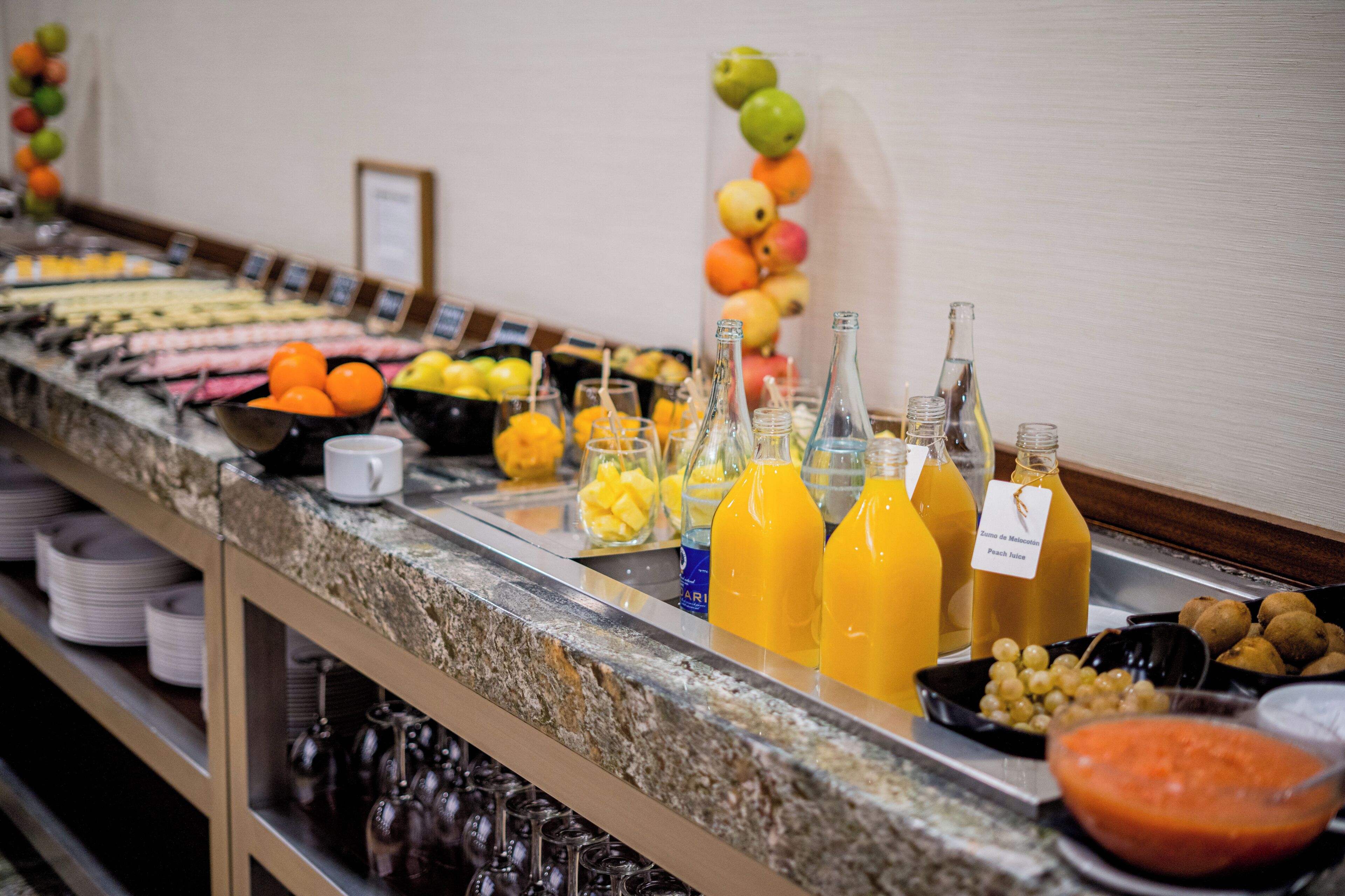 Un buffet proposant une variété de fruits, de boissons et d’assaisonnements.