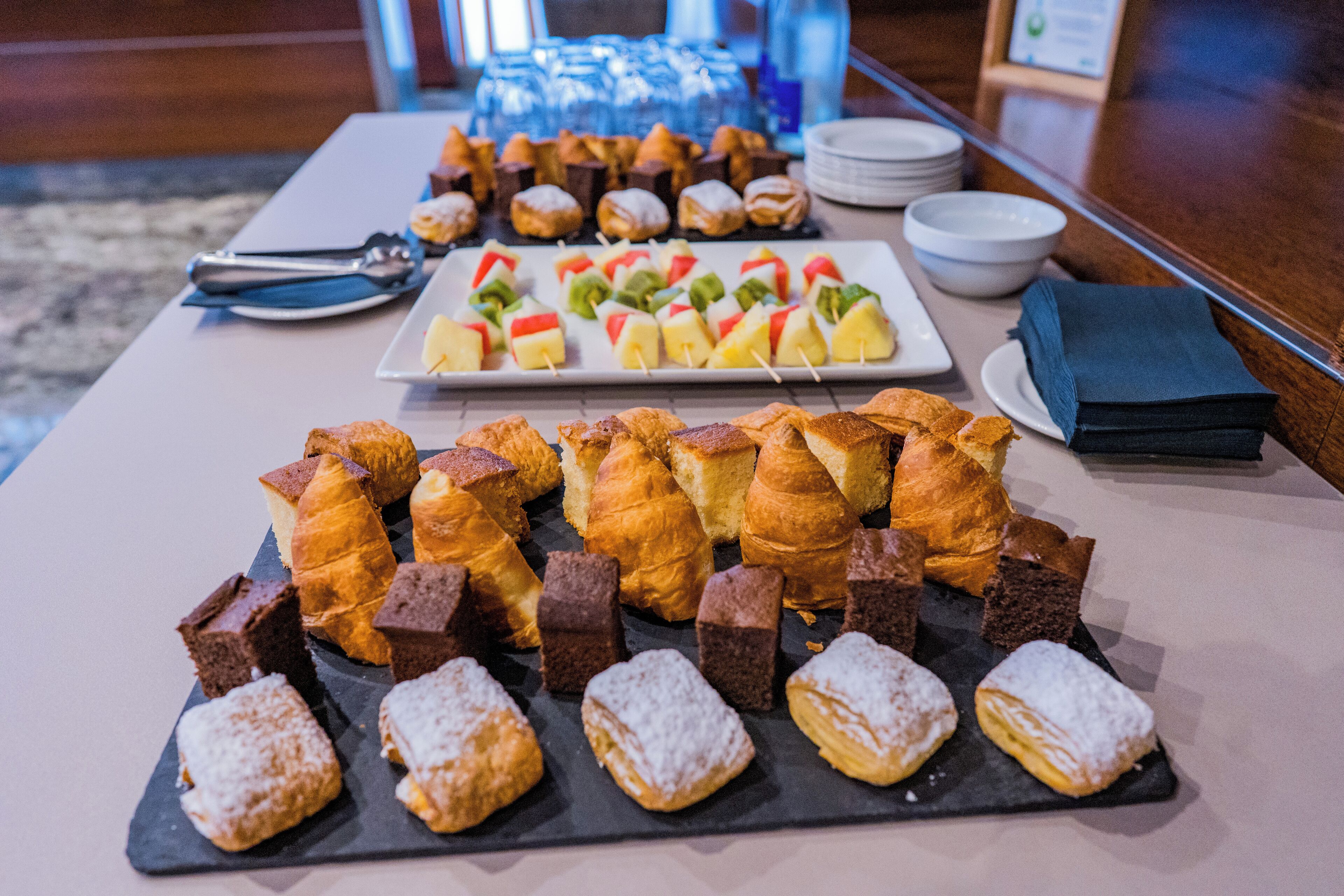 Una mesa de buffet con varios pasteles y postres.