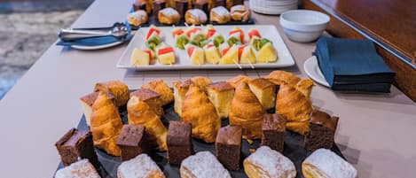 Una mesa de buffet con varios pasteles y postres.