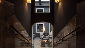 A staircase leading to a living area with a sofa, armchairs, and a lamp. - Hesperia Barri Gòtic (Barcelona)