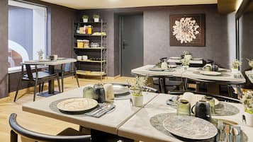 Un comedor moderno con varias mesas, sillas y una estantería empotrada.