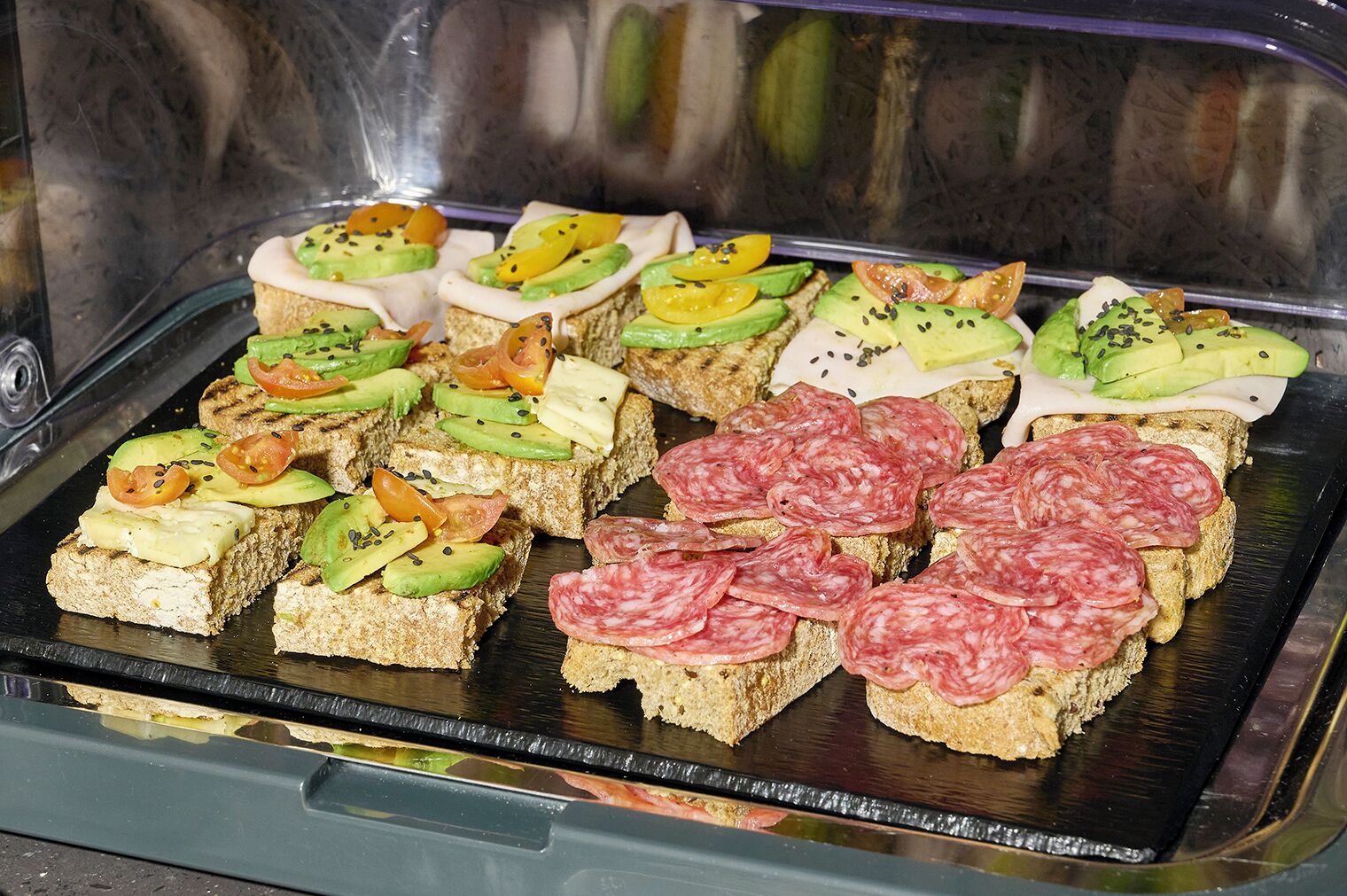 Una bandeja con una selección de sándwiches y diferentes ingredientes.