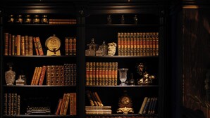 A library with bookshelves, a globe, and a clock. - Hesperia Barri Gòtic (Barcelona)