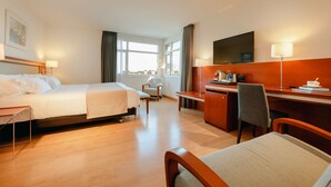 A hotel room with a bed, desk, chair, and a TV. - Abba Euskalduna Hotel (Bilbao)