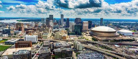 A cityscape with a large stadium, high-rise buildings, and a parking lot.