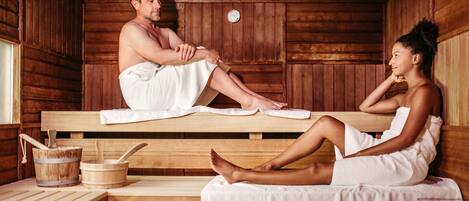 A sauna room with wooden benches and benches, a wooden bucket, and a wooden table.